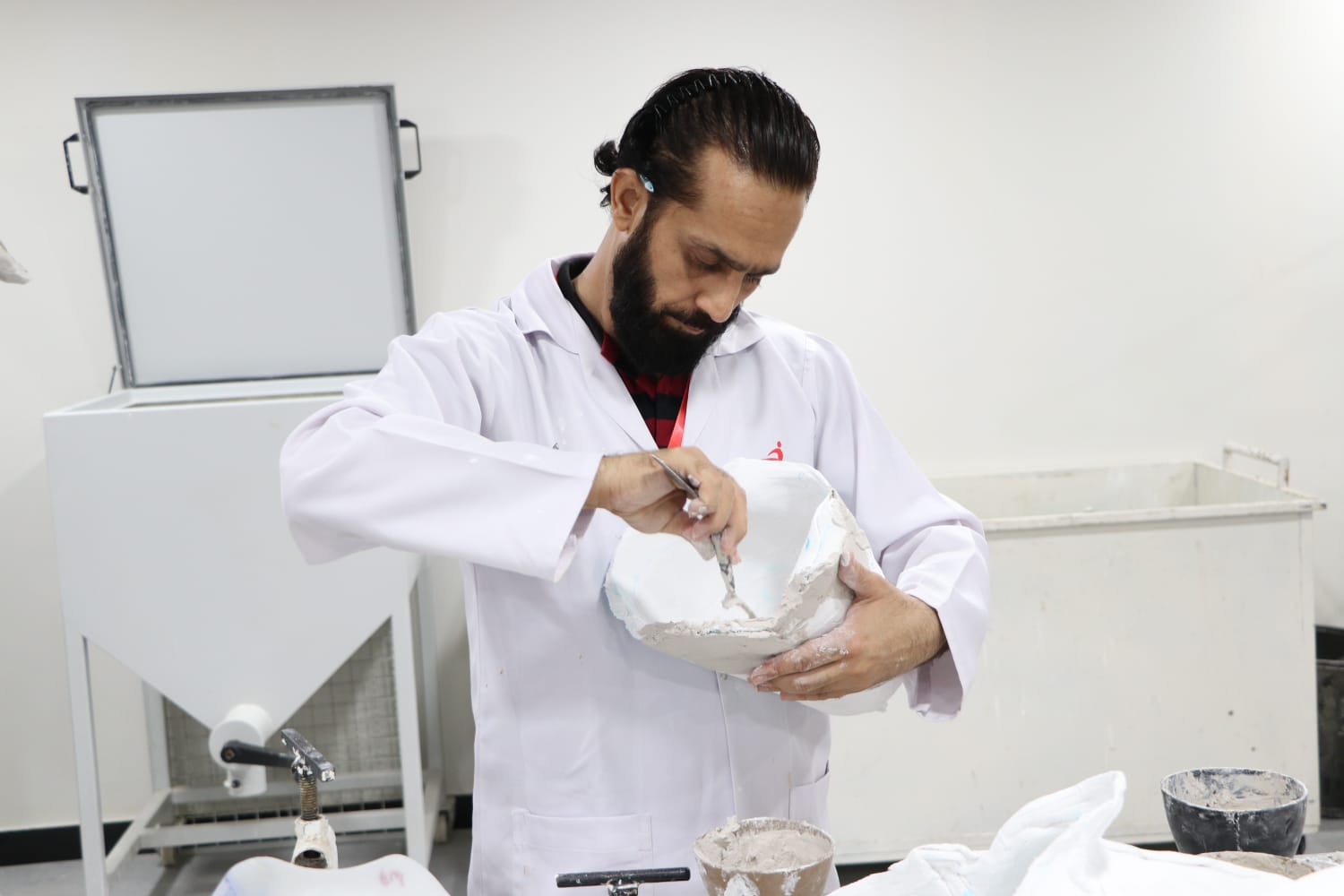 Specialist modifying a plaster model during fabrication
